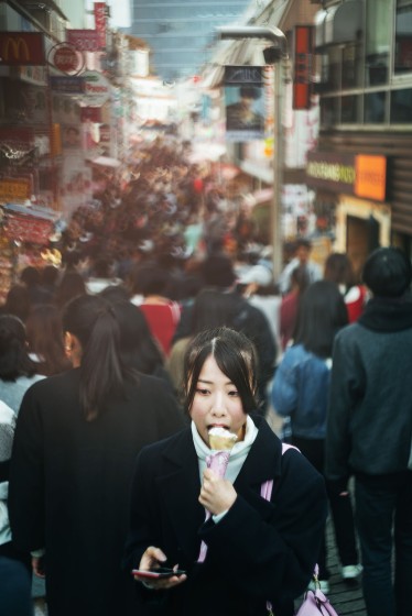 High school girl eating crepes in Harajuku